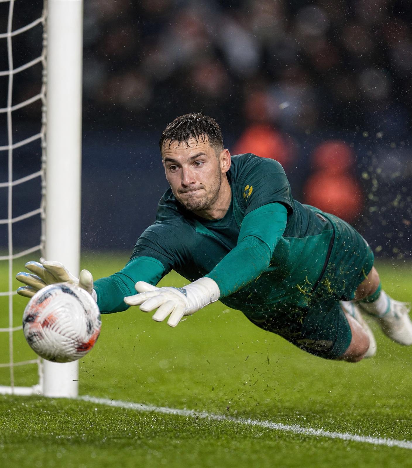 Rosedale Soccer Club goalkeeper diving to make a save under floodlights